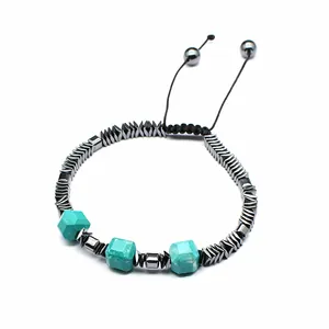 Detalle de pulsera tejida a mano con piedras turquesa en cubo y cuentas de hematita