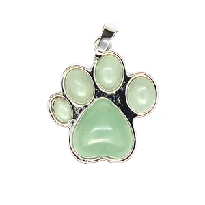 Detalle de un colgante de pata de perro en piedra natural verde con marco plateado.
