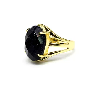 Macro detail of a vintage oval blue sandstone ring with an adjustable gold band.