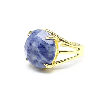 Detailaufnahme eines facettierten blauen Natursteinrings mit goldfarbenem Ringband