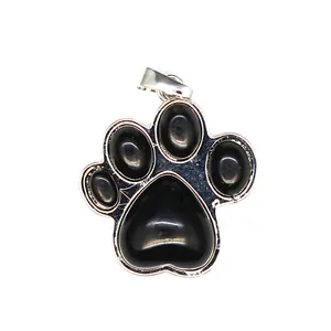 Primer plano de un colgante de pata de perro con piedras negras y marco plateado