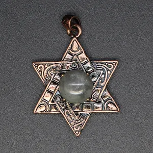 Gros plan d'un pendentif hexagramme en bronze vintage avec une pierre naturelle