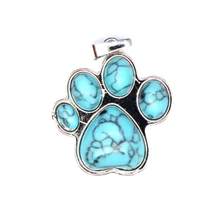 Vista macro detallada de un colgante de piedra turquesa con diseño de pata de perro.