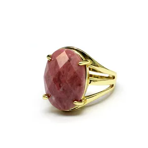 Detailed view of oval faceted pink natural stone ring with vintage gold setting