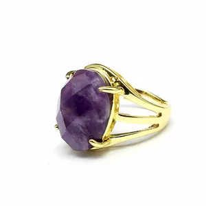 Close-up detail view of a retro golden open ring featuring a large oval faceted purple stone