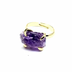 Macro detail of natural raw purple amethyst stone set on a gold adjustable ring