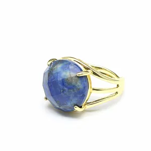 Nahaufnahme eines luxuriösen facettierten blauen Natursteinrings mit goldenem Band.