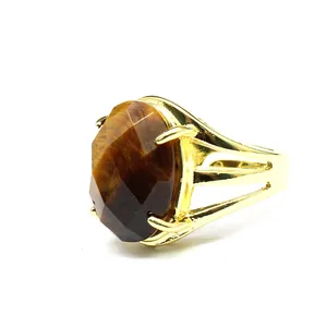 Detailed view of a vintage gold-plated ring with a large oval faceted brown tiger's eye stone.
