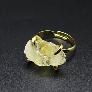 Close-up detail of a natural raw crystal ring with an adjustable gold-plated claw setting