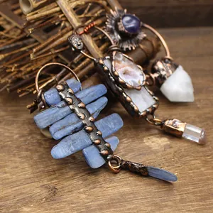 Macro detail of vintage raw crystal pendants with bronze finish on wooden background