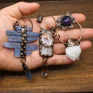 Detail of three vintage natural stone pendants featuring kyanite, amethyst, and clear quartz.