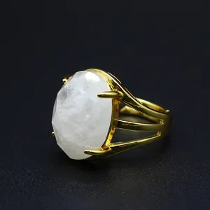 Macro view of a large oval faceted white natural stone on a vintage gold-toned ring