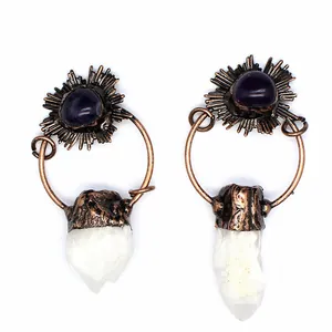 Close-up of vintage style copper earrings with amethyst and raw white crystal points