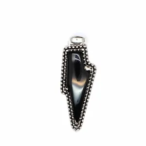 Detail view of a vintage lightning-shaped pendant featuring a polished black natural stone