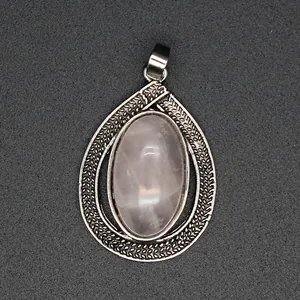 Close-up of vintage teardrop silver pendant with oval pink crystal stone