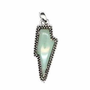 Detailed macro view of a vintage lightning bolt pendant with pale green natural stone inlay.