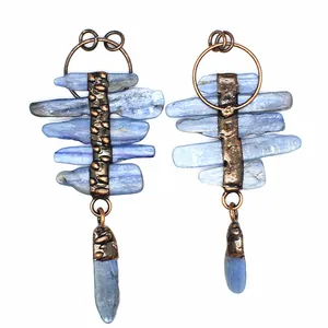 Close-up of vintage irregular raw blue kyanite pendants with hammered bronze metal frame