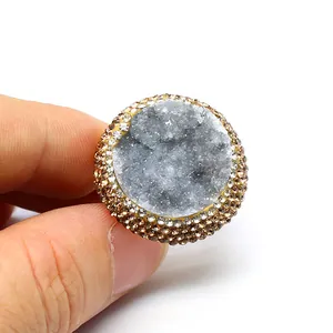 Macro detail of natural druzy agate ring with handmade gold-tone rhinestone border
