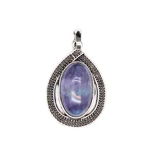 Macro detail of a vintage oval purple stone teardrop pendant in a carved silver setting