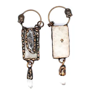 Detail view of vintage-style pendants with white crystal quartz and Buddha head accents