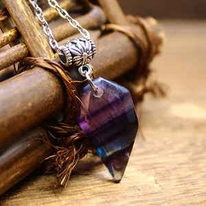 Close-up detail of a faceted purple and green natural fluorite crystal pendant necklace