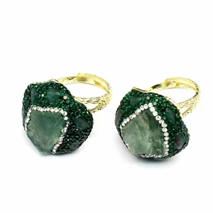 Detailed view of handmade adjustable rings featuring raw green natural stones and crystals.