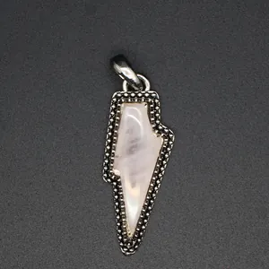 Detailed view of vintage rose quartz lightning bolt pendant with beaded metal frame