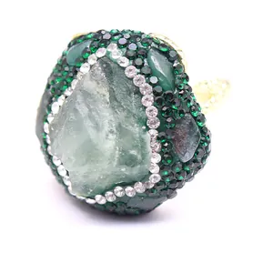 Detailed view of an oversized natural green stone ring with handmade crystal pave setting