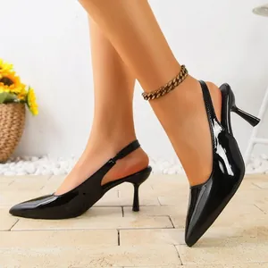 Elegant black patent leather pointed-toe slingback kitten heels shown on model in studio