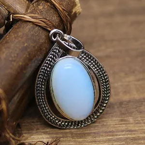 Macro detail of vintage oval drop pendant with opal stone and textured silver frame