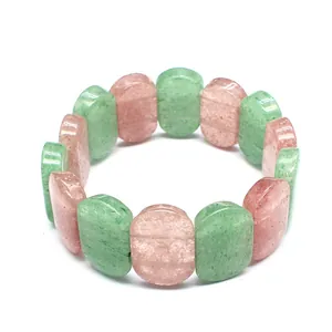 Close-up detail of polished oval green and pink natural stone beads on a stretch bracelet