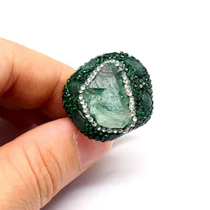 Close-up detail of a handmade green natural stone ring with sparkling pave crystal setting.