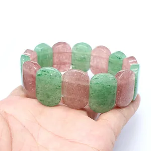 Close-up detail of smooth oval strawberry quartz and green natural stone stretch bracelet
