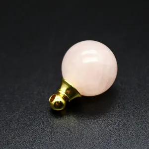 Dettaglio macro di un pendente per aromaterapia in quarzo rosa da 16 mm, base oro