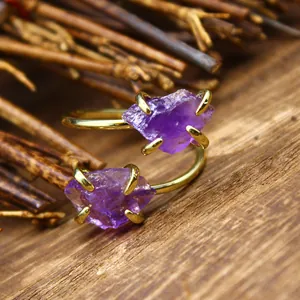 Macro detail of natural raw amethyst double stone ring with four-prong gold plated setting