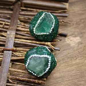 Macro detail of handmade natural green stone rings with sparkling rhinestone accents