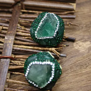Detailed macro view of large green natural stone ring with sparkling crystal pave