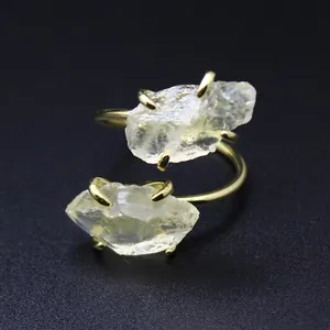 Macro view of a double raw clear crystal adjustable ring with gold claw settings