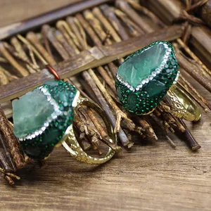 Close-up of handcrafted natural green stone rings with crystal pave and gold band