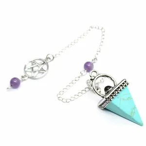 Gros plan d'un pendule pyramide turquoise rétro avec breloque pentagramme en argent