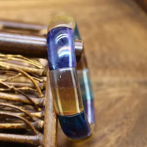 Detailed close-up of a colorful natural stone crystal bracelet featuring polished rectangular beads