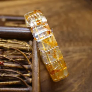 Macro view of a natural yellow rutilated quartz crystal hand plate bracelet with golden inclusions