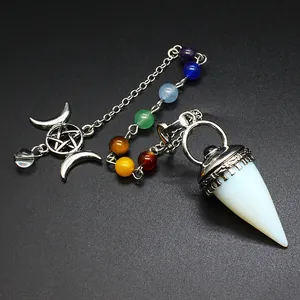 Primer plano de un péndulo de cristal con cuentas de chakra y un amuleto de luna.