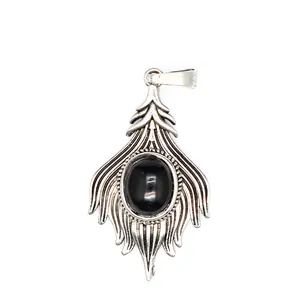 Macro detail of a vintage silver-tone pendant with an oval black gemstone inlay