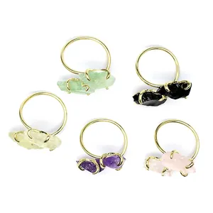Detailed view of colorful natural raw stone rings featuring amethyst and rose quartz
