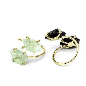 Detailed view of two adjustable raw stone rings in light green and black colors