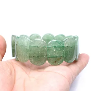 Close-up detail of a minimalist 11x18mm oval green natural stone bracelet held in hand