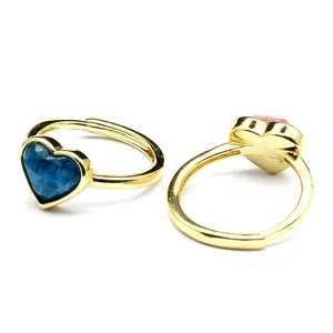 Detail shot of heart-shaped natural gemstone rings with faceted blue and pink crystals.