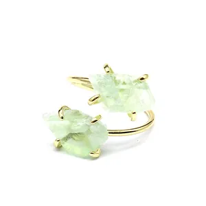 Detailed macro view of natural green raw stone ring with gold four-prong setting