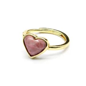 Detailed macro view of a faceted heart-shaped pink stone ring with a gold-tone band.